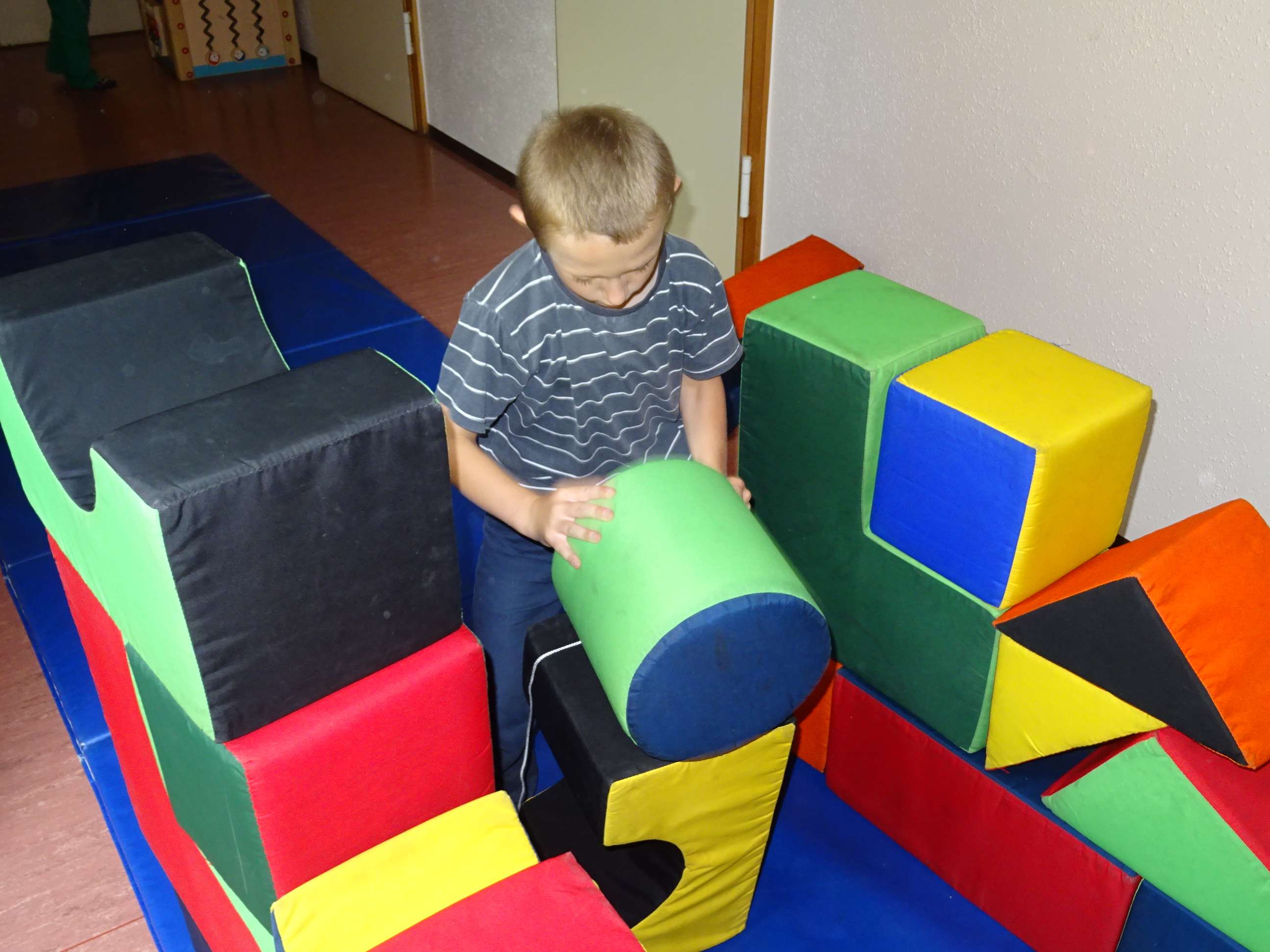  Ein Kind spielt mit großen Bausteinen - das Bild wird mit Klick vergrößert 